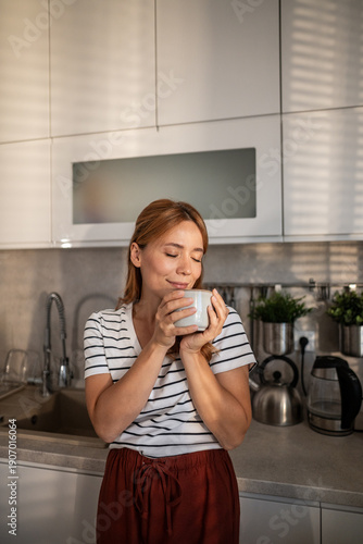 Photos Woman enjoying coffee ritual in morning kitchen