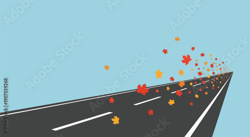 A long, straight road with autumn leaves blowing in the wind under a blue sky, depicting the fall season.