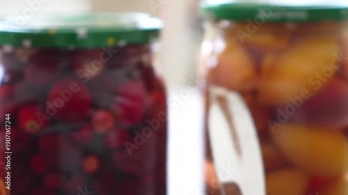 Preserved fruits and berries in glass jars, homemade goodness for healthy eating.