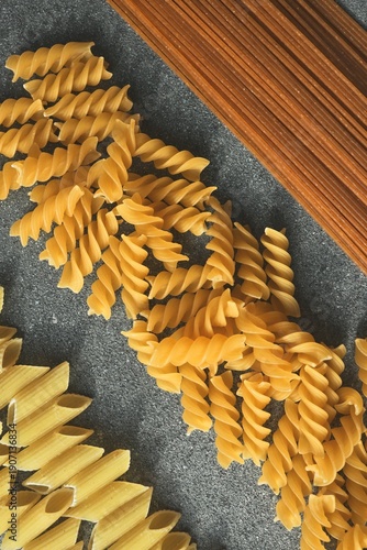 Foto Assortment of dry pasta shapes including fusilli, penne, and whole wheat spaghet