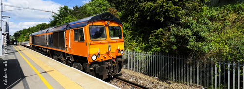 panoramic shot of goods train passing through british rail great british railways station