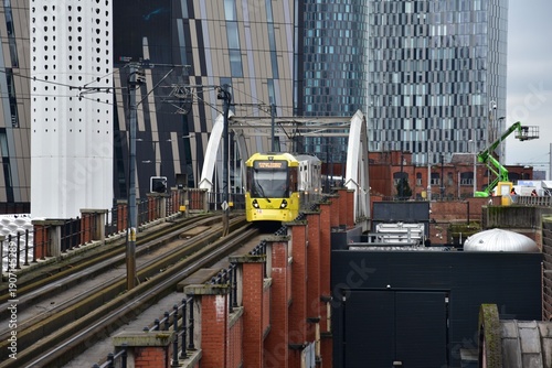 Manchester city centre with yellow tram and landmark buildings. Manchester England. 