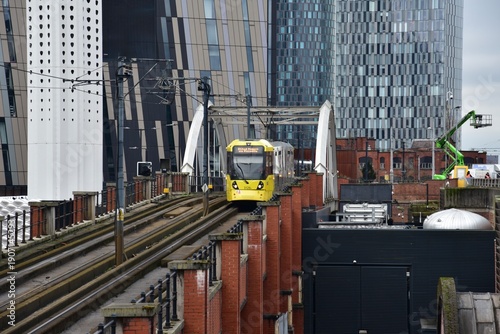 Manchester city centre with yellow tram and landmark buildings. Manchester England. 