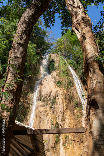 Limestone Waterfall Framed by Trees in Tropical Forest