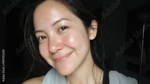 Natural skincare close-up of young woman with fresh dewy skin and towel after shower in minimal makeup beauty portrait in soft window light with calm expression