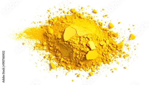 Pile of bright yellow, granulated powder and solid shards scattered on a white surface, lit from above