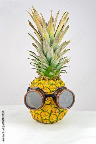 Wallpaper Mural Funny pineapple wearing vintage steampunk goggles on light background, quirky tropical concept, minimal studio style Torontodigital.ca
