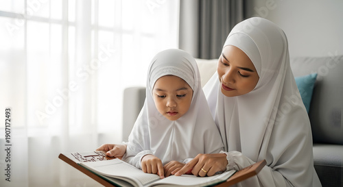A realistic stock photo of a Muslim mother teaching her young daughter to read the Quran at home, both wearing modest white prayer clothing, child pointing at the pages of the Quran, gentle guidance a