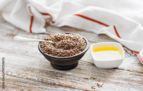 Photos Organic linseed oil and seeds on rustic wooden surface, healthy nutrition