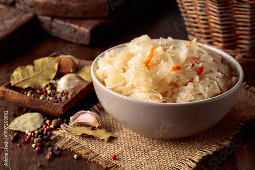 Homemade sauerkraut with carrot on an old wooden table.