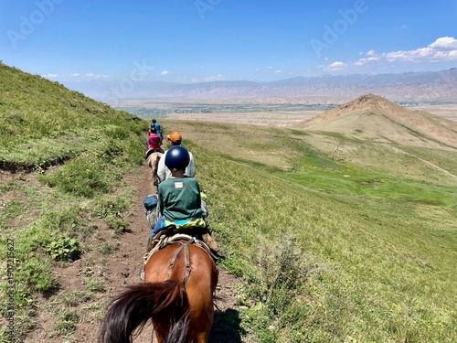 Horse riding in the breathtaking landscape of Song Kul Lake, Kyrgyzstan.