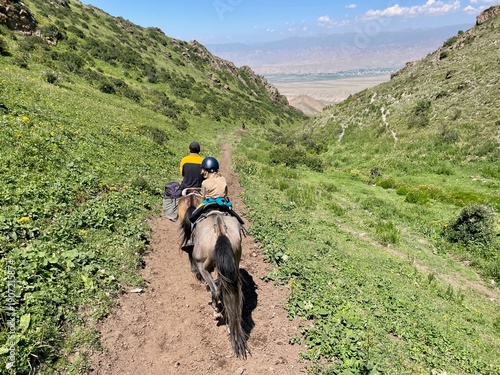 Horse riding in the breathtaking landscape of Song Kul Lake, Kyrgyzstan.