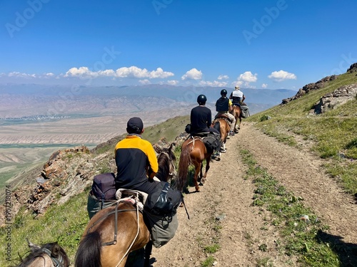 Horse riding in the breathtaking landscape of Song Kul Lake, Kyrgyzstan.