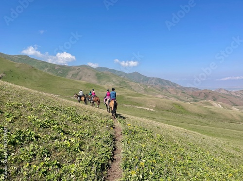Horse riding in the breathtaking landscape of Song Kul Lake, Kyrgyzstan.