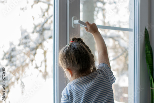 Little girl opens the window. Children safety at home. Prevention of falling accident Free Download Little girl opens the window. Children safety at home. Prevention of falling accident - GFXLoad