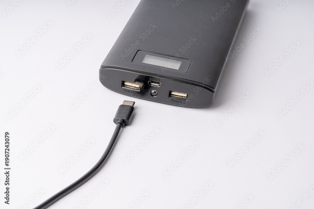 Obraz premium Modern Black Power Bank with USB-C Cable for Mobile Device Charging