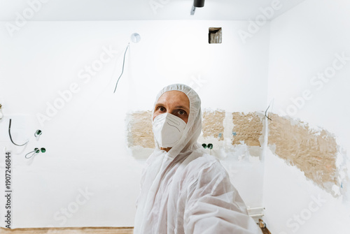 Photos Inspector In Protective Gear Assesses Room
