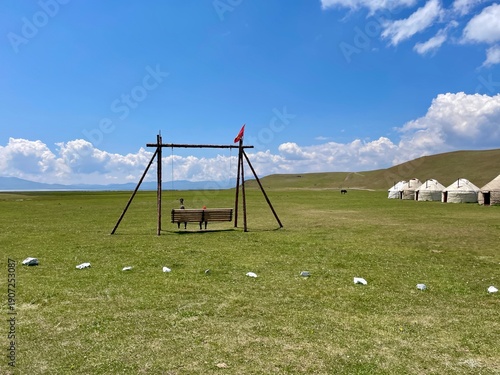 Nomadic lifestyle with traditional yurts and a giant swing at Song Kul Lake, Kyrgyzstan.