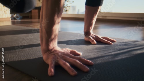 Strong hands press on yoga mat during balance work in morning