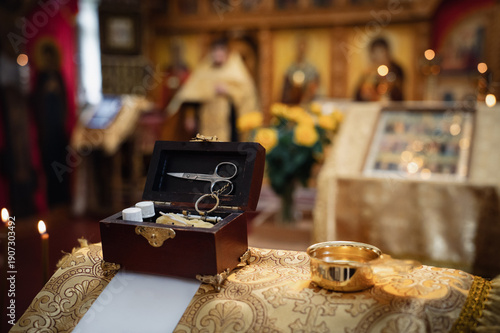 Sacrament of Baptism in Orthodox Church. Items for ceremony, image in yellow-brown tones