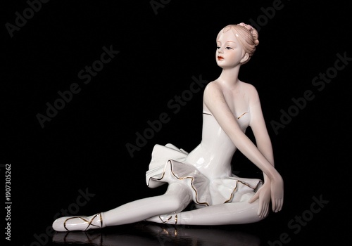 Bild auf Leinwand A porcelain figurine of a ballerina on a black background.