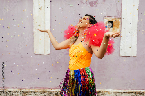 Fotografi Woman dancing and throwing confetti during carnival street parade, expressing ha