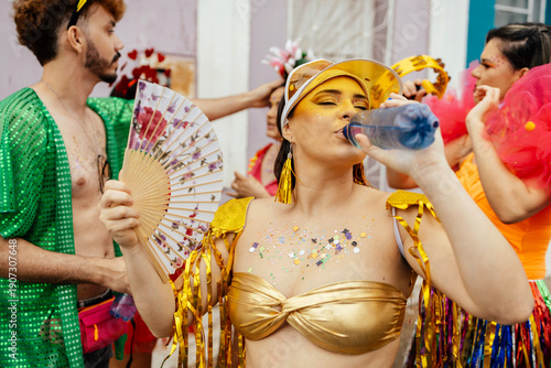 Sticker Woman drinking water during carnival street festival, showing hydration, health