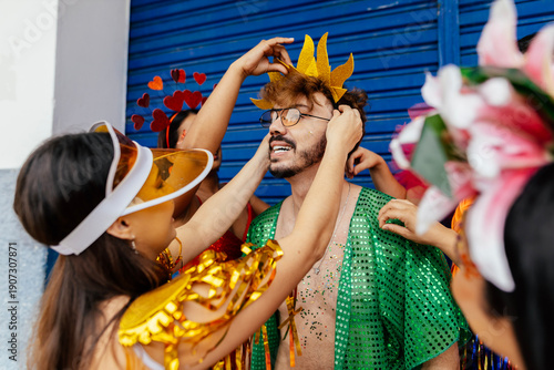 Foto Friends laughing together while adjusting carnival headpieces and costumes during preparation for a Brazilian street parade