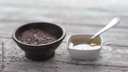 Organic linseed oil and seeds on rustic wooden surface, healthy nutrition.