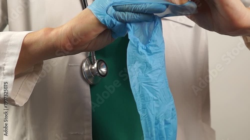 A healthcare professional removes and prepares to discard used protective gloves, demonstrating adherence to medical waste and safety protocols.