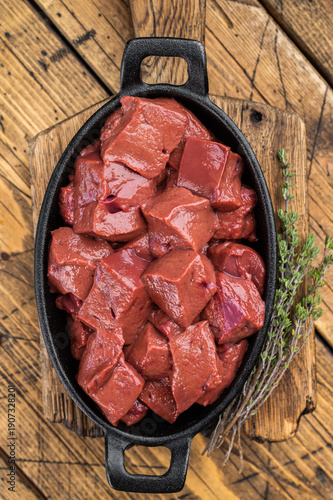 Obraz na plátně Fresh diced beef calf liver prepared for cooking in skillet on wooden background