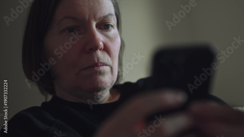 Close-up portrait of a woman using a smartphone, thoughtful and worried mood, soft lighting creating an intimate and realistic atmosphere. 4K