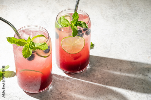 Fresh berry drinks with mint on a simple background