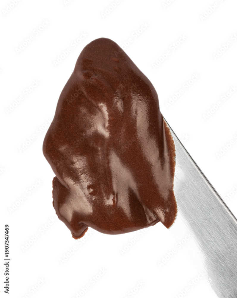 Obraz premium Chocolate cream on metal knife isolated on white background. Smooth glossy cocoa spread texture, close up. Ideal for food advertising, packaging, dessert design, branding and culinary concepts.