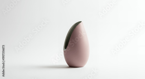 Pink teardrop shaped vase with green interior on white background