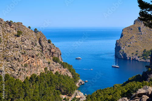 Breathtaking view of Sa Calobra bay with boats on turquoise blue water, Balearic Islands, Spain.