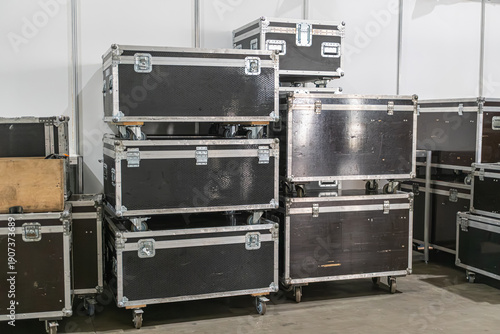 Tableau sur toile Black flight cases arranged on a concrete floor, possibly in a warehouse or stor