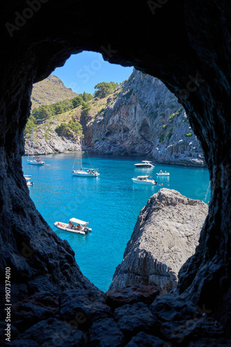 Breathtaking view of Sa Calobra bay with boats on turquoise blue water, Balearic Islands, Spain.