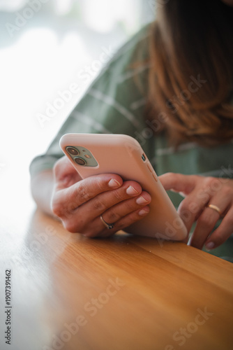 Detail of a woman's hand using her touchscreen cell phone. Concept of mobile technology, digital communication, social media, online shopping, or remote work. Close-up image with selective focus 
