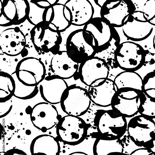 Seamless pattern of coffee cup stains with circular rings and spilled coffee marks forming grunge texture on white background.