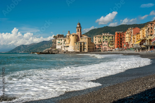 coast of the fishing town of Camogli, colorful houses and fortress, waves of sea