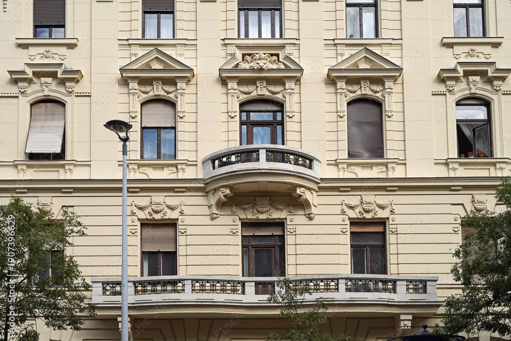 Obraz premium Facade of ornate old apartment bulding with large and small balcony
