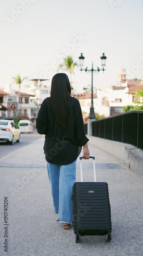 Mexican tourist walking with a suitcase in downtown puerto vallarta