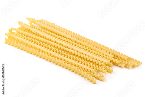Golden yellow mafaldine pasta, neatly arranged in parallel rows, awaiting preparation for a delicious Italian meal, isolated on white background
