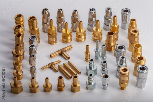 Large collection of brass and steel pneumatic fittings including hose barbs and quick couplers, professional industrial hardware assortment for fluid engineering and workshop maintenance systems