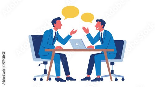 Two businessmen in blue suits discussing a project on a laptop at a wooden desk in a modern office setting.