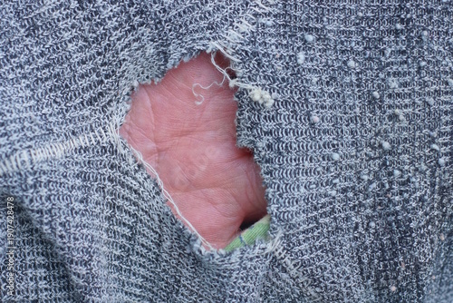 a piece of gray cloth on old torn clothes with a big  hole