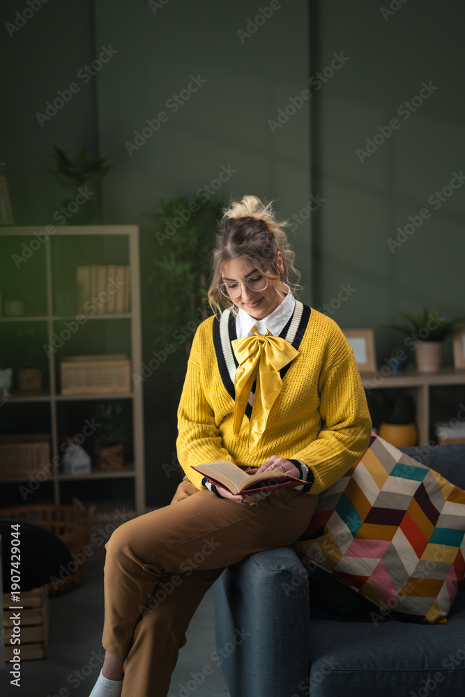 Fototapeta premium Young woman enjoying quiet time reading book at home