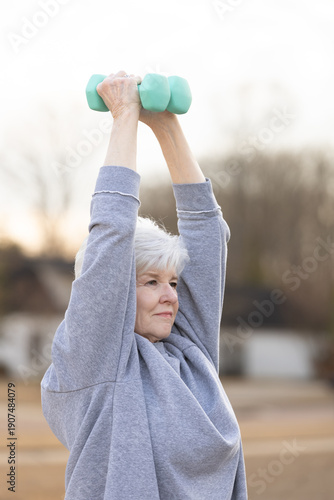 Side view of senior woman lifting dumbbell during workout