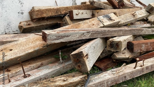A pile of scrap wood with rusty nails in a building project area, showing the rough texture, construction waste materials, as well as the concept of renovation, building waste, and industry.